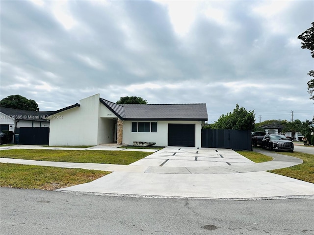 ranch-style home with a garage and a front lawn