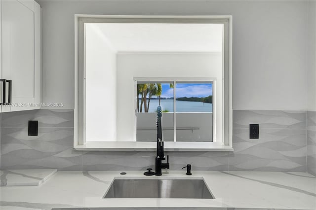 500 Bayview Dr Unit 118, Sunny Isles Beach, FL 33160 - kitchen view of a sink, tasteful backsplash, light stone countertops, and white cabinetry
