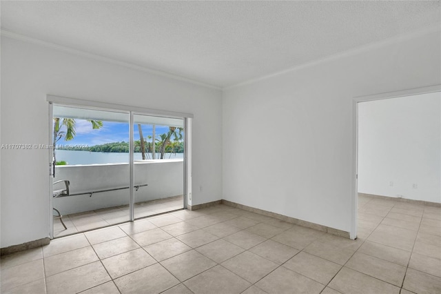 tiled empty room with crown molding, a textured ceiling, and a water view