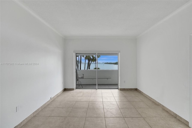 spare room featuring light tile patterned floors, a textured ceiling, and crown molding