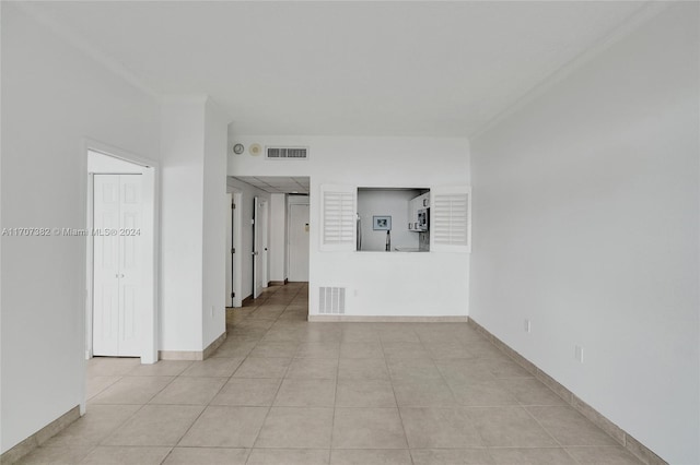 tiled spare room with crown molding