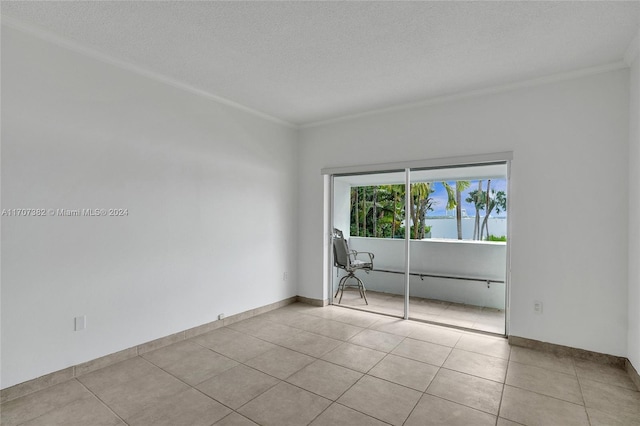 tiled empty room with a textured ceiling and crown molding