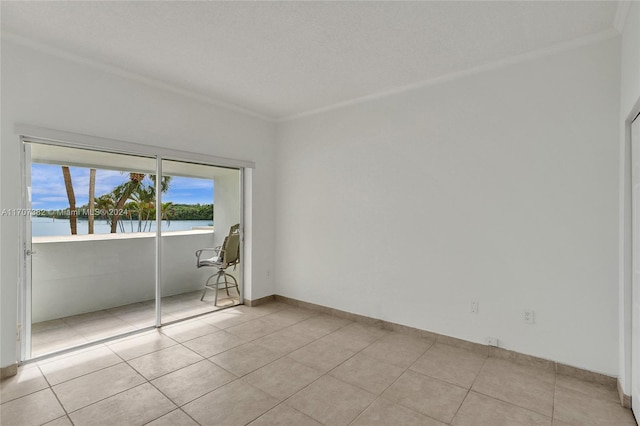 tiled spare room featuring crown molding, a water view, and a textured ceiling