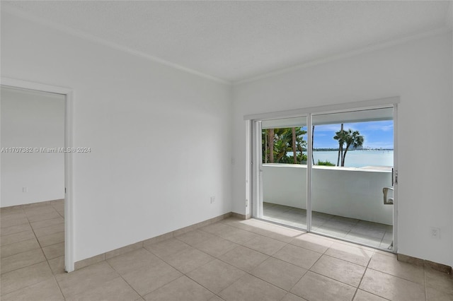 unfurnished room with crown molding, light tile patterned floors, and a textured ceiling