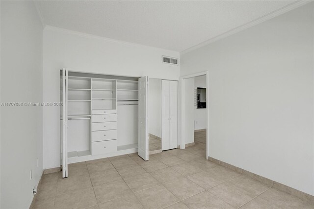 500 Bayview Dr Unit 118, Sunny Isles Beach, FL 33160 - unfurnished bedroom with ornamental molding, multiple closets, and light tile patterned flooring