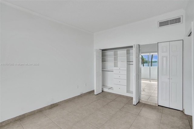 500 Bayview Dr Unit 118, Sunny Isles Beach, FL 33160 - unfurnished bedroom with ornamental molding, light tile patterned floors, and two closets