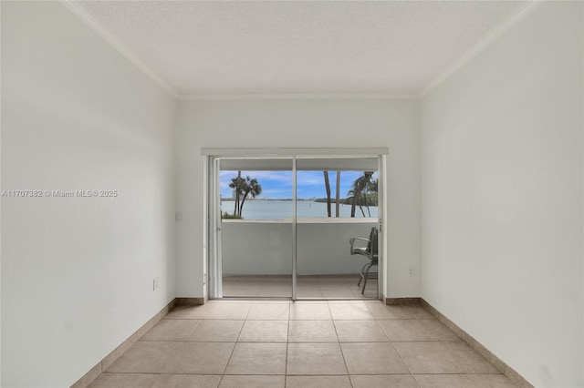 500 Bayview Dr Unit 118, Sunny Isles Beach, FL 33160 - spare room featuring crown molding, a water view, light tile patterned flooring, baseboards, and a textured ceiling