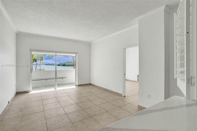 empty room with light tile patterned floors, a textured ceiling, and ornamental molding