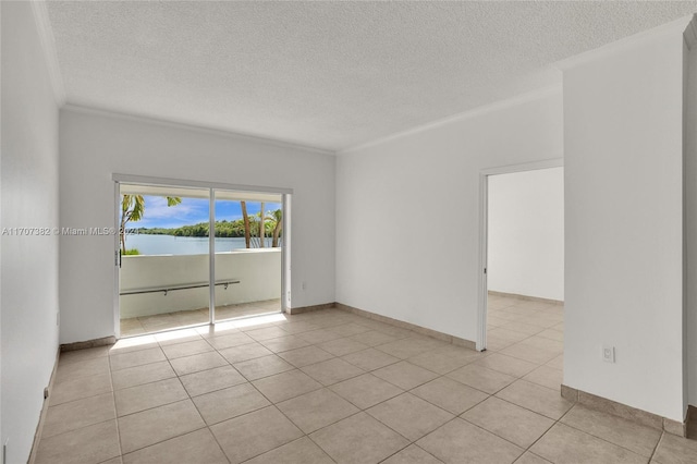 tiled spare room featuring a textured ceiling and crown molding