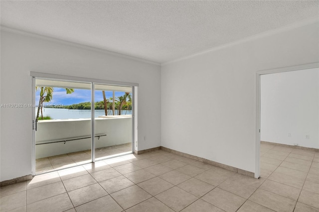 tiled empty room with crown molding, a water view, and a textured ceiling