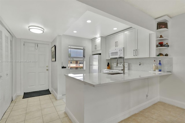 kitchen with kitchen peninsula, white cabinetry, light tile patterned flooring, and white appliances