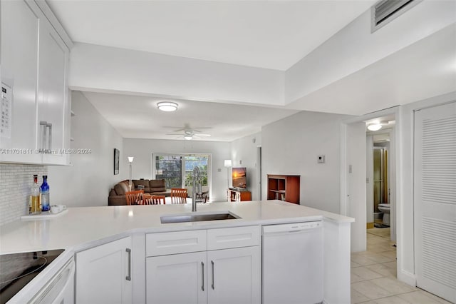 kitchen with dishwasher, kitchen peninsula, white cabinets, and sink