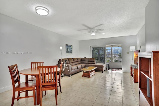 tiled dining area featuring ceiling fan and a textured ceiling