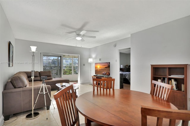 tiled dining area with ceiling fan and a textured ceiling