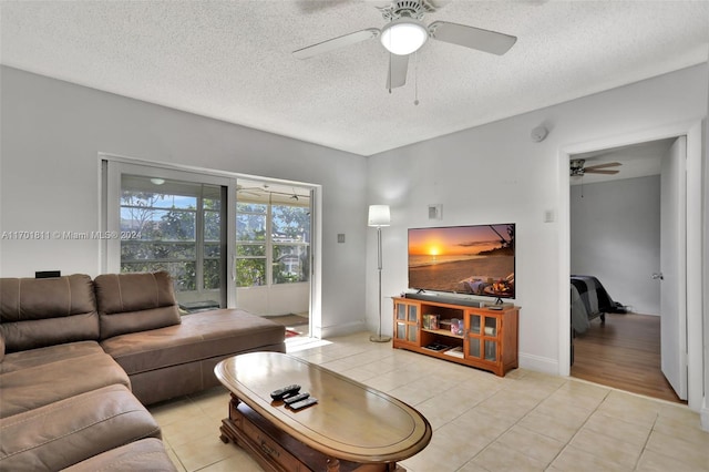 tiled living room with a textured ceiling and ceiling fan