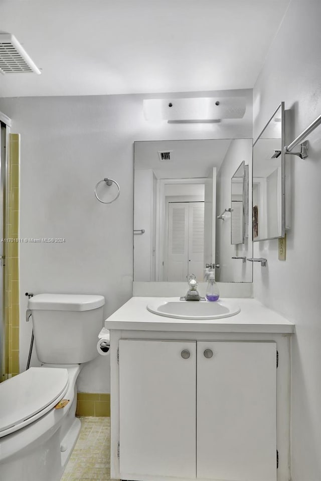 bathroom with tile patterned flooring, vanity, and toilet