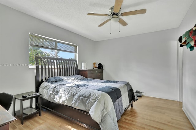 bedroom featuring a textured ceiling, light hardwood / wood-style floors, and ceiling fan