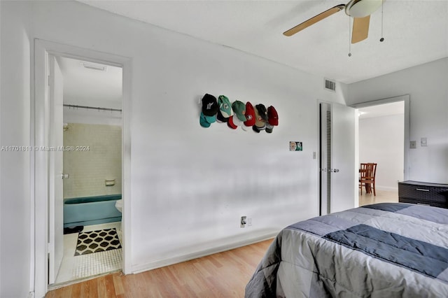 bedroom with ceiling fan, ensuite bathroom, and wood-type flooring