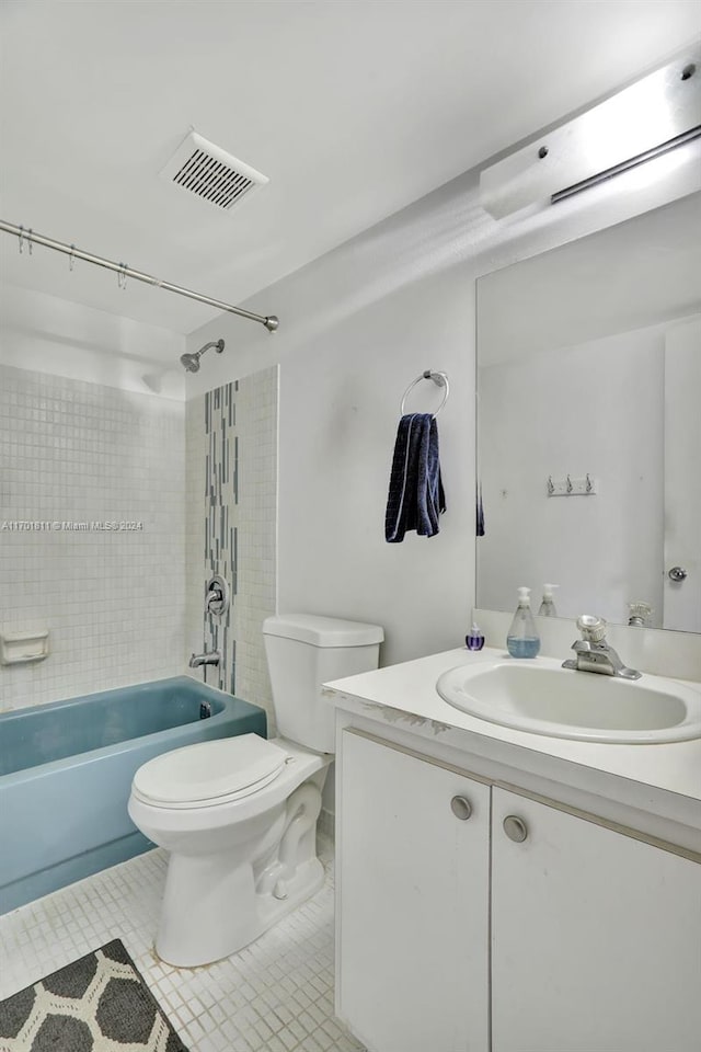 full bathroom with tile patterned floors, tiled shower / bath combo, toilet, and vanity