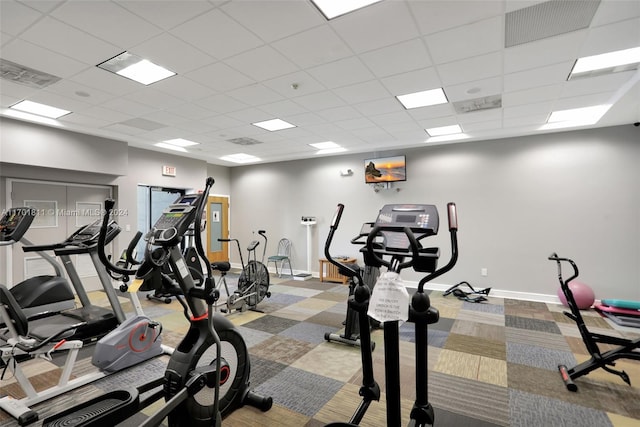 gym with a drop ceiling and light carpet