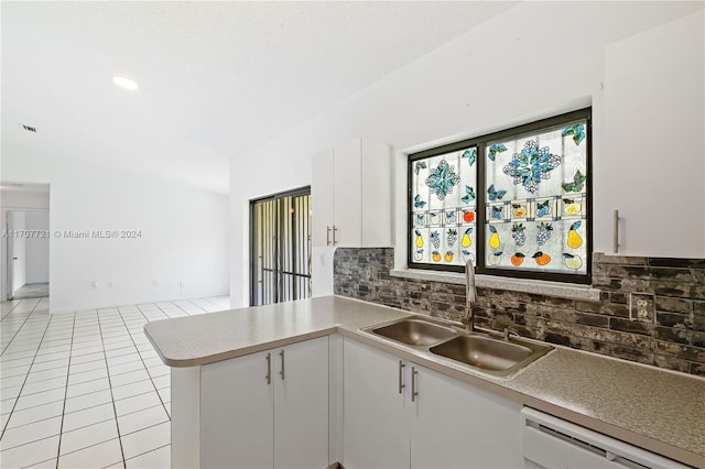 kitchen with dishwasher, sink, tasteful backsplash, light tile patterned flooring, and white cabinetry