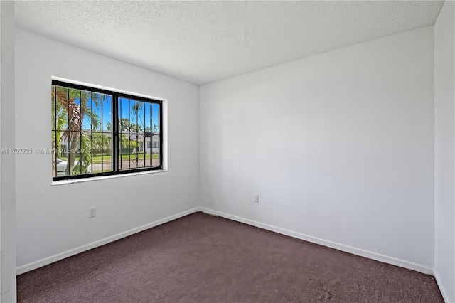 carpeted spare room with a textured ceiling