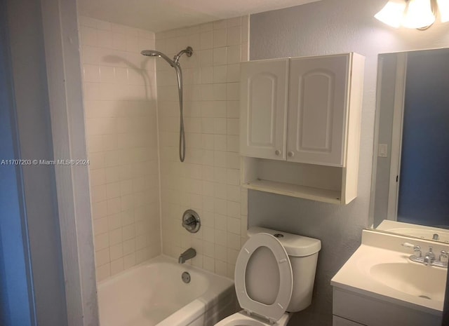 full bathroom with vanity, tiled shower / bath combo, and toilet