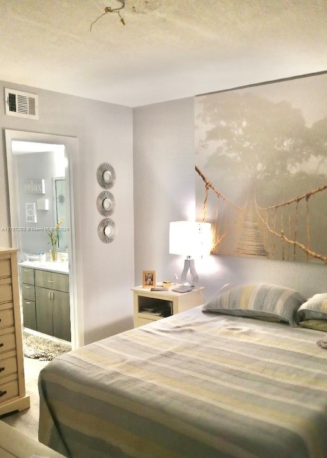 bedroom with a textured ceiling and ensuite bath