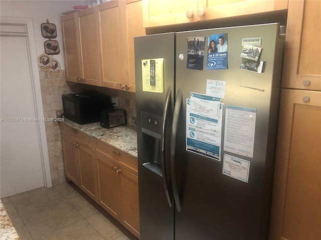 kitchen featuring stainless steel fridge with ice dispenser, light brown cabinets, light tile patterned floors, and light stone countertops