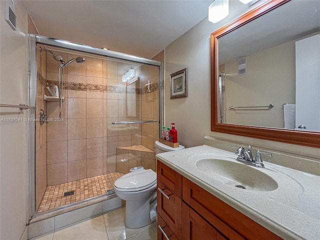 bathroom with tile patterned floors, a shower with door, vanity, and toilet