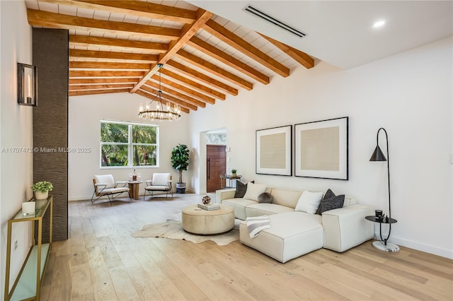 living room featuring a notable chandelier, vaulted ceiling with beams, and light hardwood / wood-style flooring