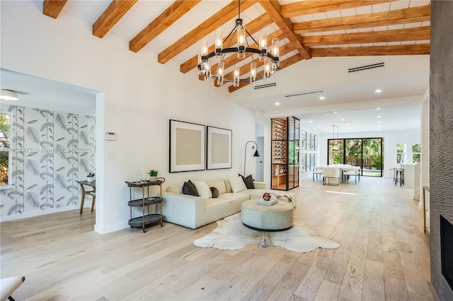 living room featuring beamed ceiling, high vaulted ceiling, an inviting chandelier, and light hardwood / wood-style flooring