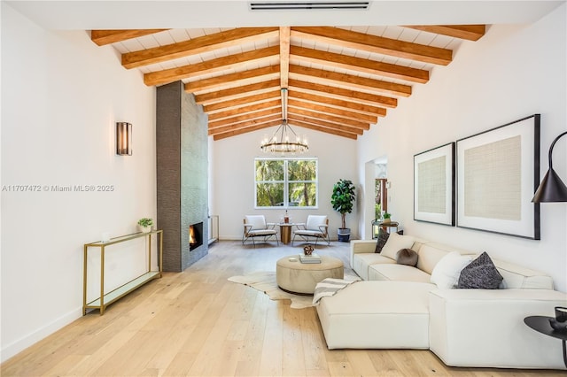 living room with a notable chandelier, lofted ceiling with beams, light wood-type flooring, and wooden ceiling