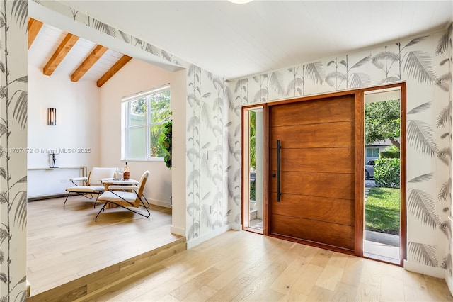 entryway featuring vaulted ceiling with beams and light hardwood / wood-style flooring