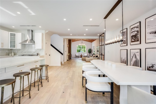 dining space with light hardwood / wood-style floors and an inviting chandelier