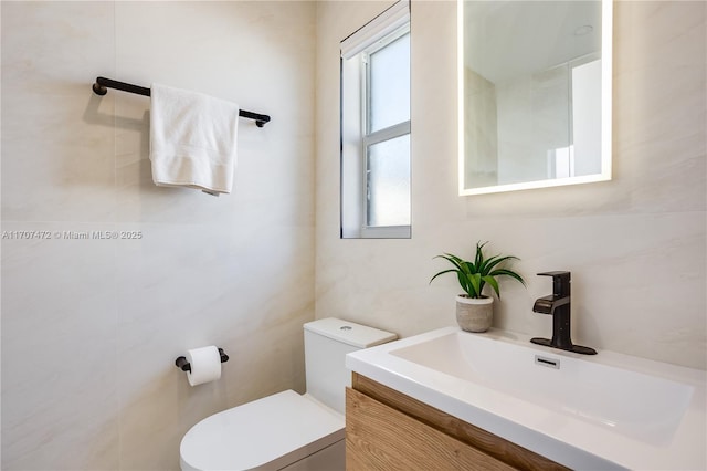 bathroom featuring vanity, toilet, and a wealth of natural light