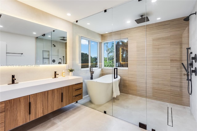 bathroom with tile patterned floors, vanity, tile walls, and independent shower and bath