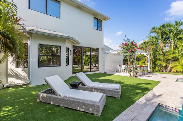 rear view of house featuring a yard and a patio area