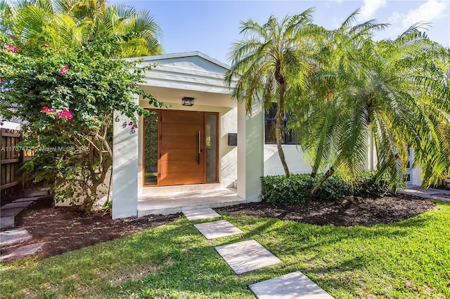 view of exterior entry with a yard