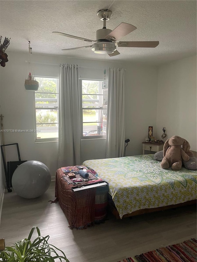 bedroom featuring ceiling fan, a textured ceiling, and light hardwood / wood-style flooring