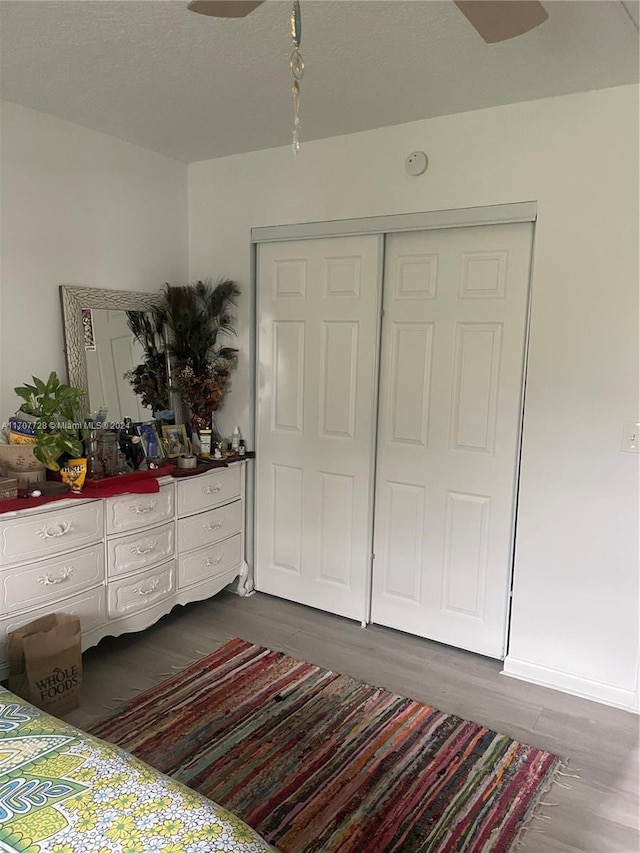 bedroom with dark hardwood / wood-style floors and a closet