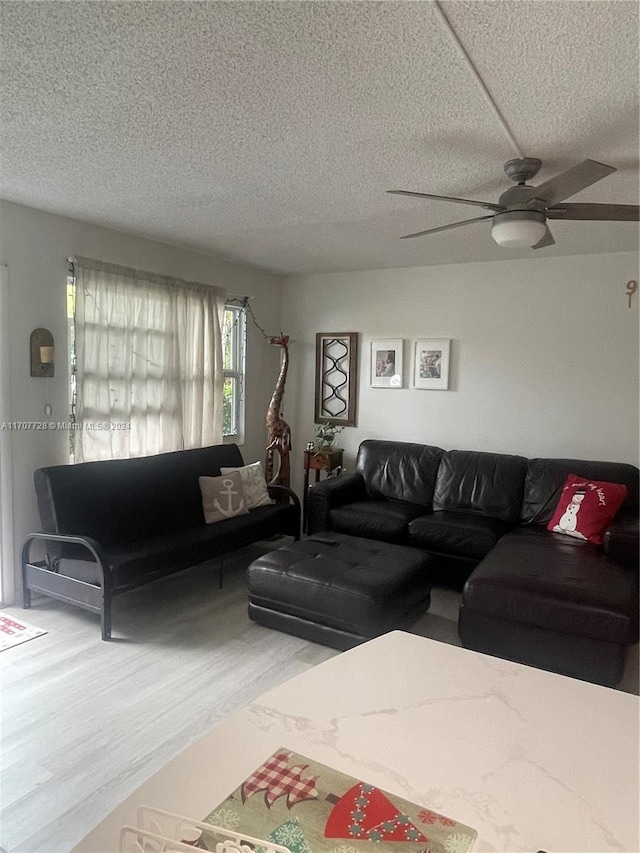 living room featuring ceiling fan and a textured ceiling