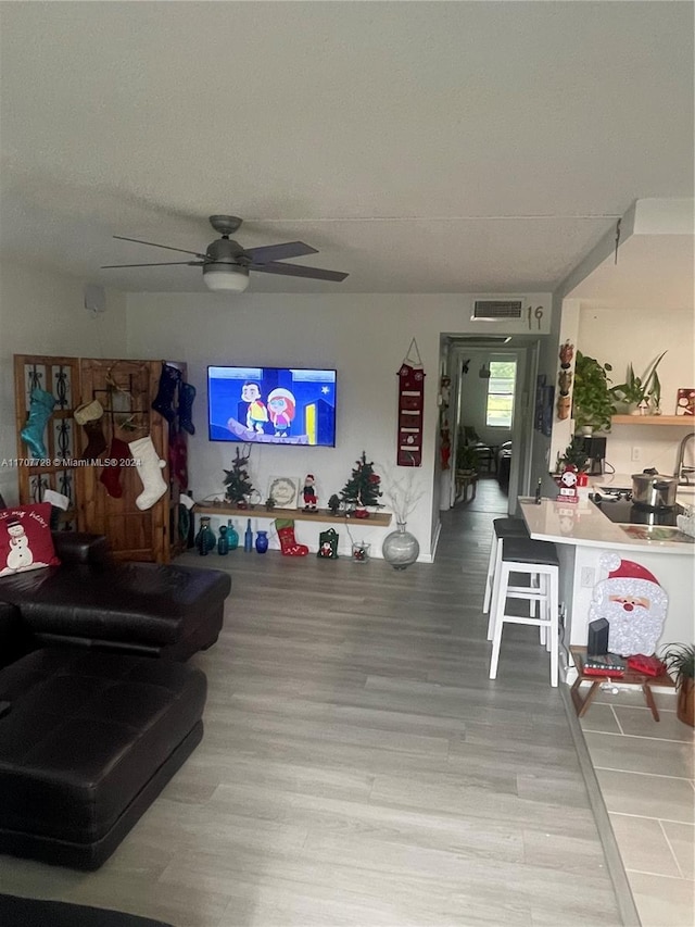 living room with ceiling fan and light hardwood / wood-style floors