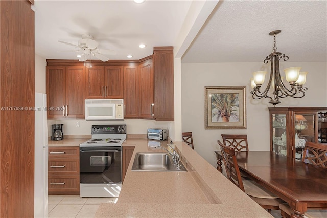 kitchen featuring pendant lighting, white appliances, ceiling fan with notable chandelier, sink, and light tile patterned floors