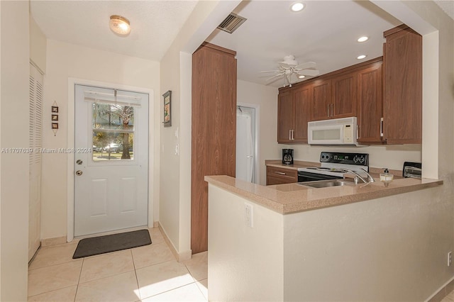 kitchen featuring ceiling fan, sink, kitchen peninsula, white appliances, and light tile patterned flooring