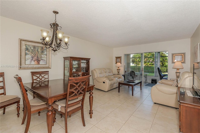 dining room featuring light tile patterned floors, a textured ceiling, and a notable chandelier