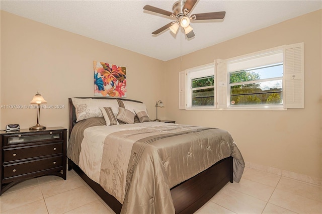 tiled bedroom with a textured ceiling and ceiling fan