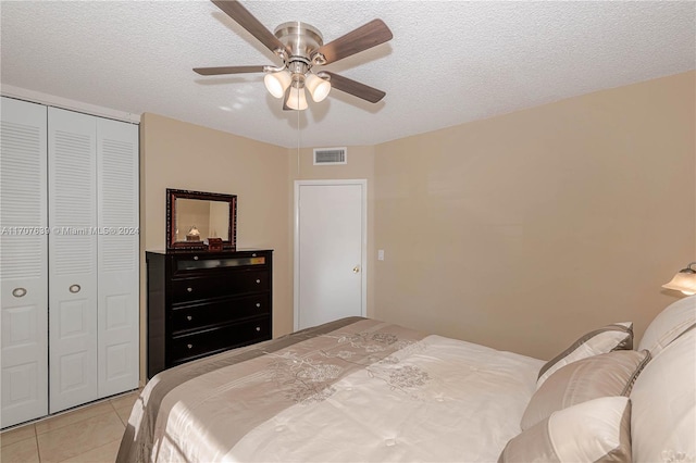 bedroom featuring ceiling fan, a closet, and a textured ceiling