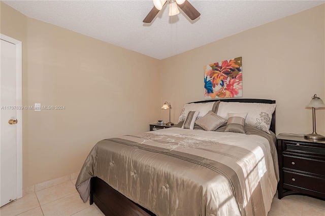 tiled bedroom with a textured ceiling and ceiling fan