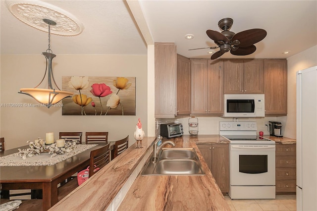 kitchen with white appliances, ceiling fan, sink, pendant lighting, and light tile patterned flooring